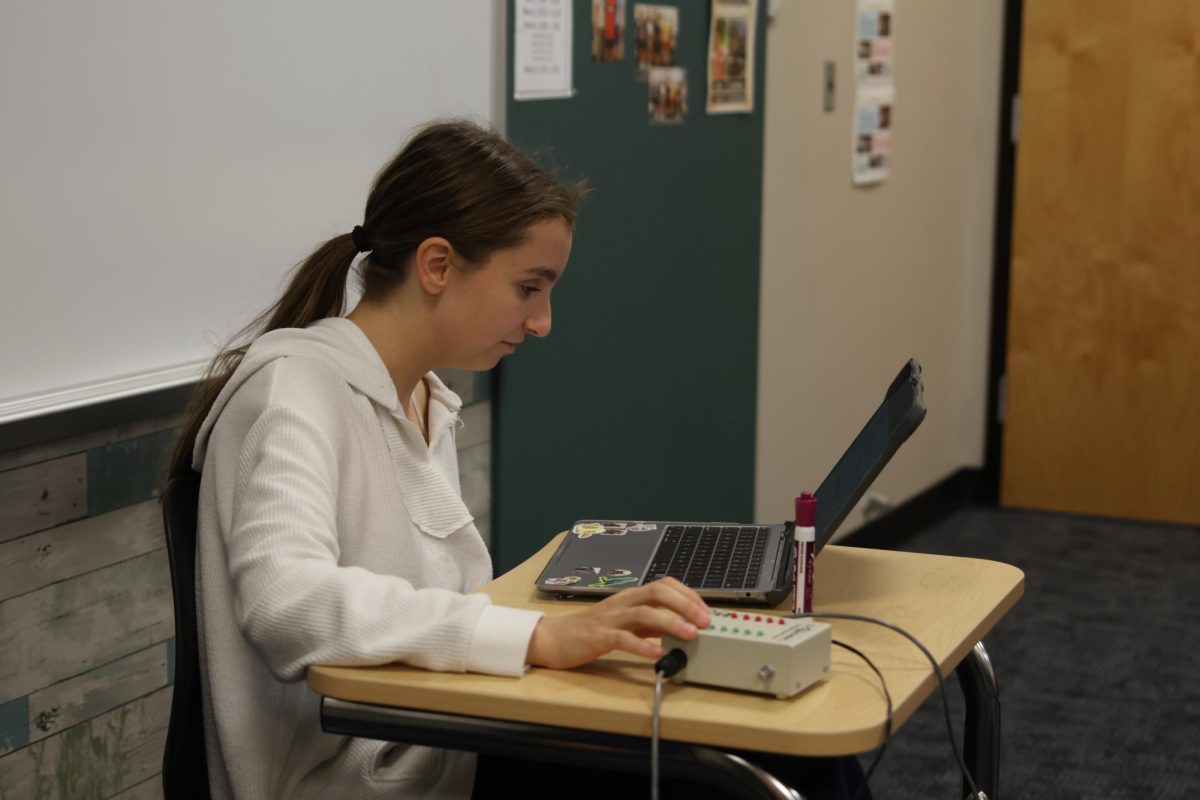Sophomore Molly Gilmore scrolls through different question documents to find a tiebreaking question during Scholars Bowl pattern. 