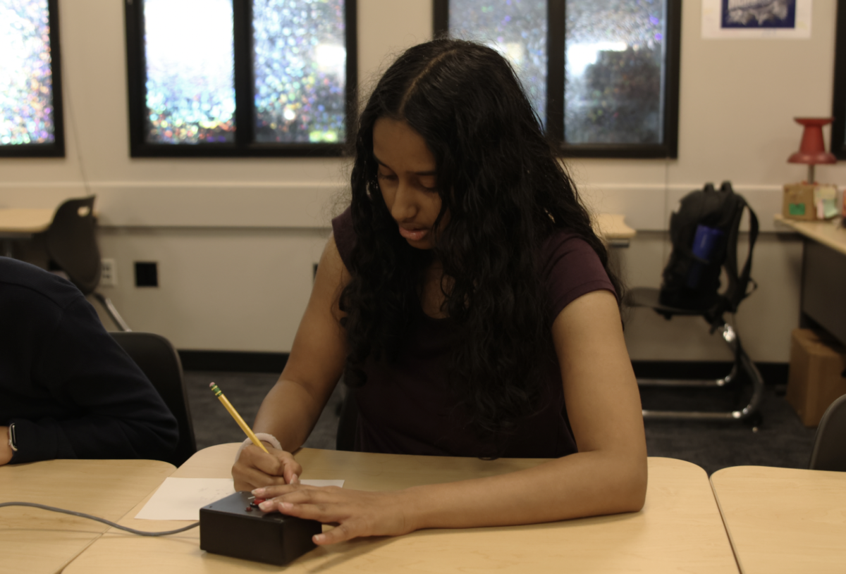 Senior Rachel Joseph takes note of a complex math problem as she mentally solves for the answer. 
