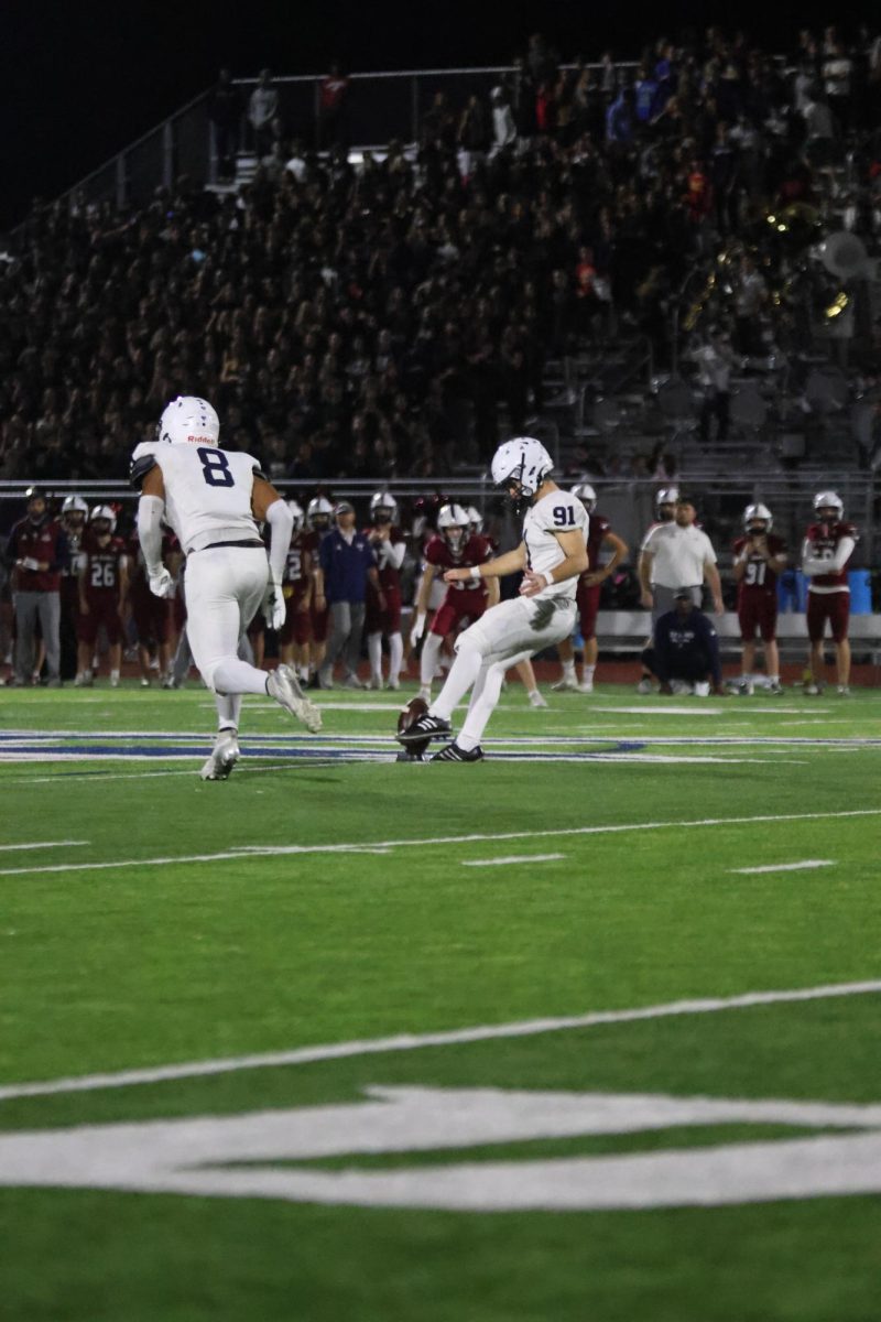 Kicker junior Mason Gallender kicks the ball down the field
