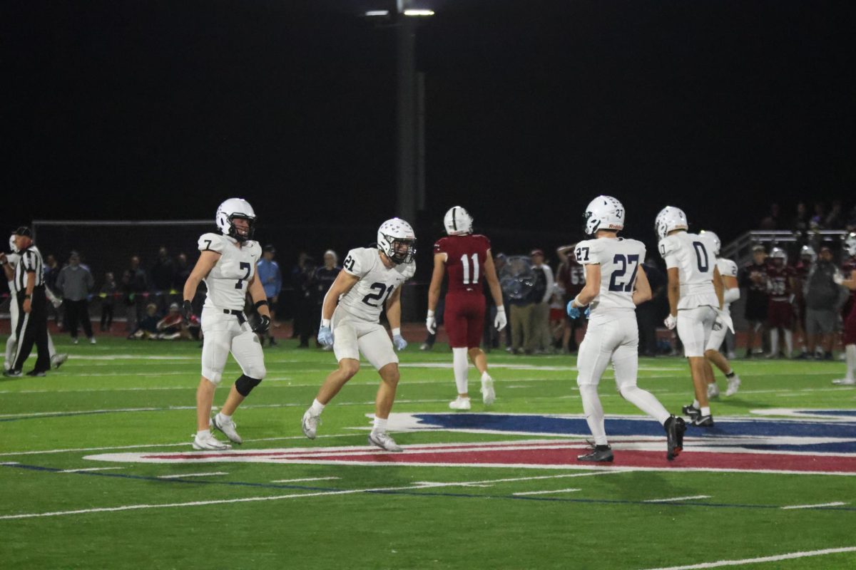 Senior Jaxon Garcia and Landon Stockwell, along with junior Braydon Jones celebrate after play.
