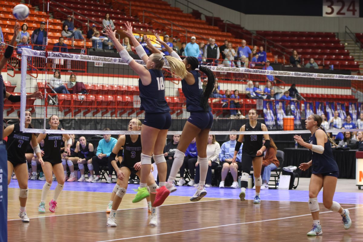 Junior Riley Riggs and senior Leilah Perry go up for a block against Olathe Northwest.