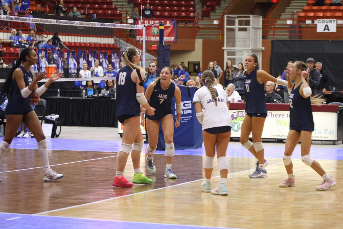 Junior Riley Riggs secures the third place trophy after her final kill of the match. The Jags won 25-22, 18-25, 26-24.