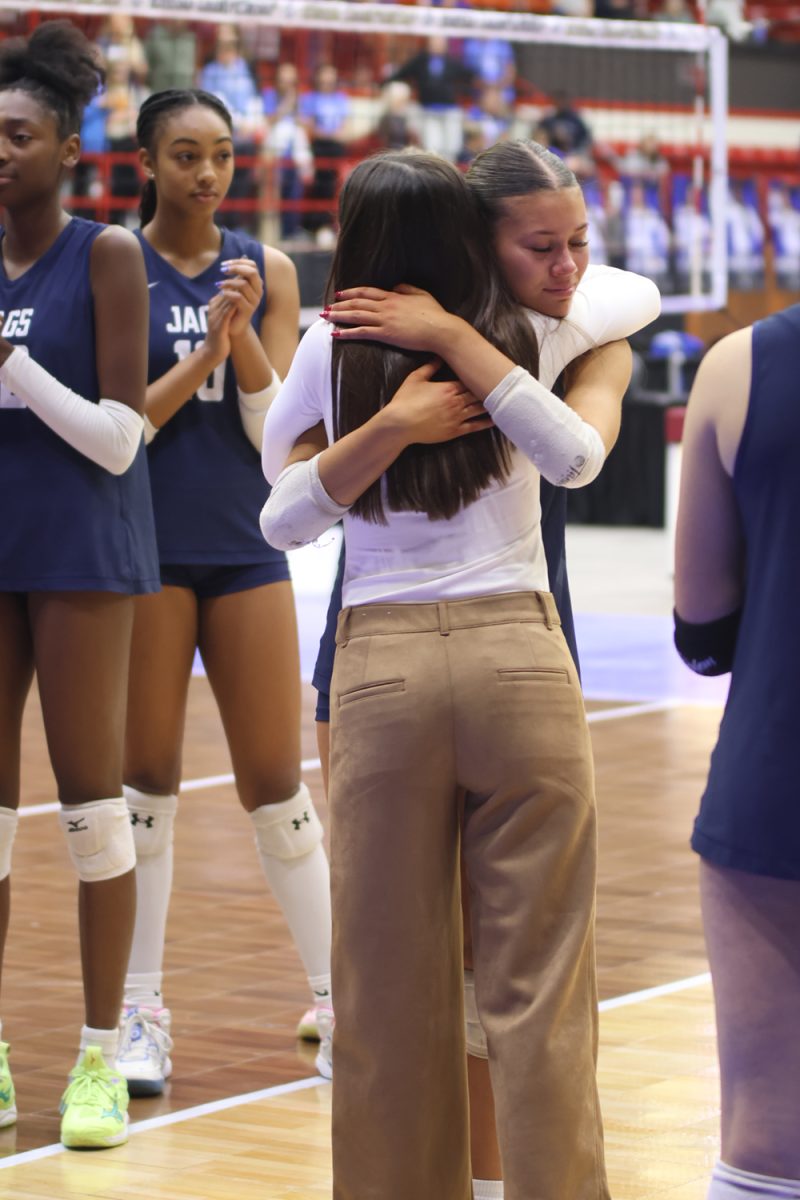 Senior Ella Florez receives a hug and her third place medal from head coach Kylie Corneliusen after the match against Olathe Northwest.