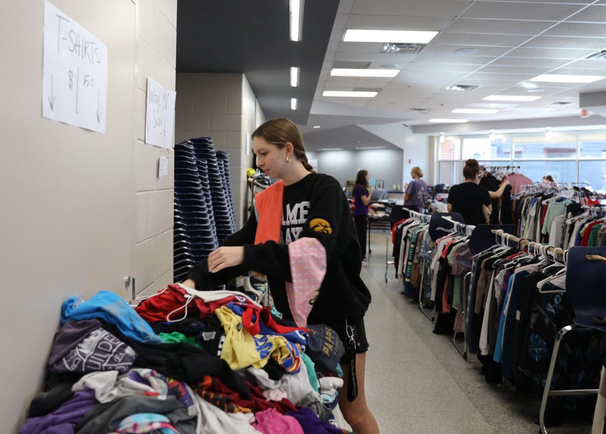 Senior Sydney Nash looks through a table of clothes during the Thrift for a Cure, searching for finds among the donated items.