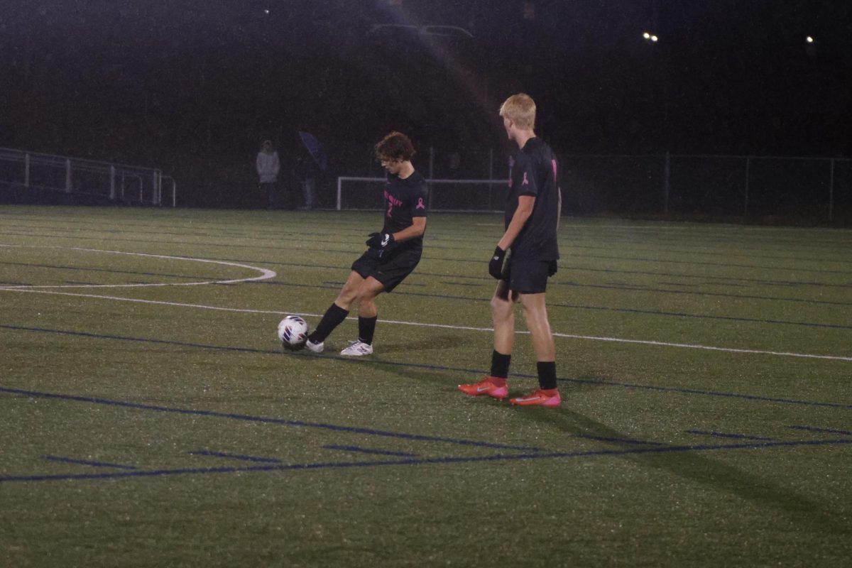 Senior Landon Vincent takes a free kick, joined by teammate Josiah Hayes, as they face off against Olathe Northwest.