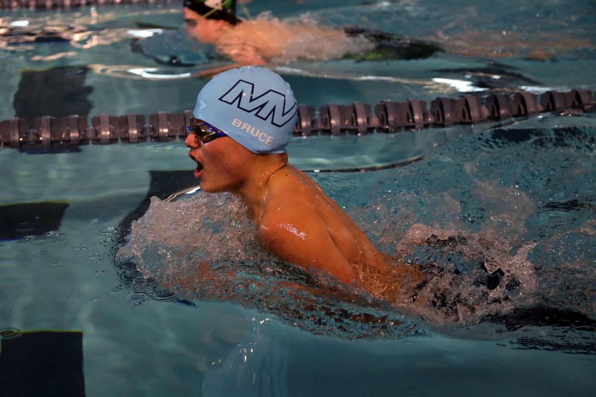 Coming up for air, sophomore Turner Bruce competes in the 100 yard breaststroke, Jan. 25, 2025
