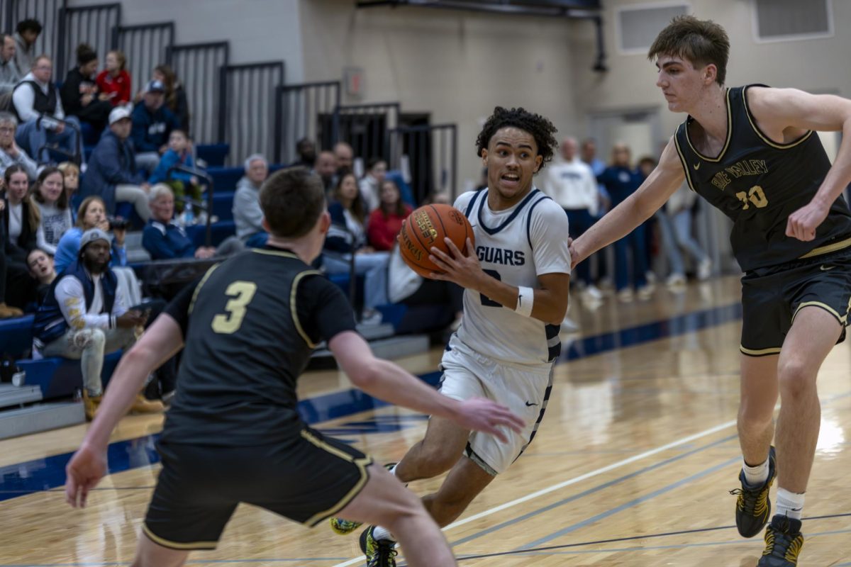 Senior JaKhai Carter dodges two defenders to reach the goal.
