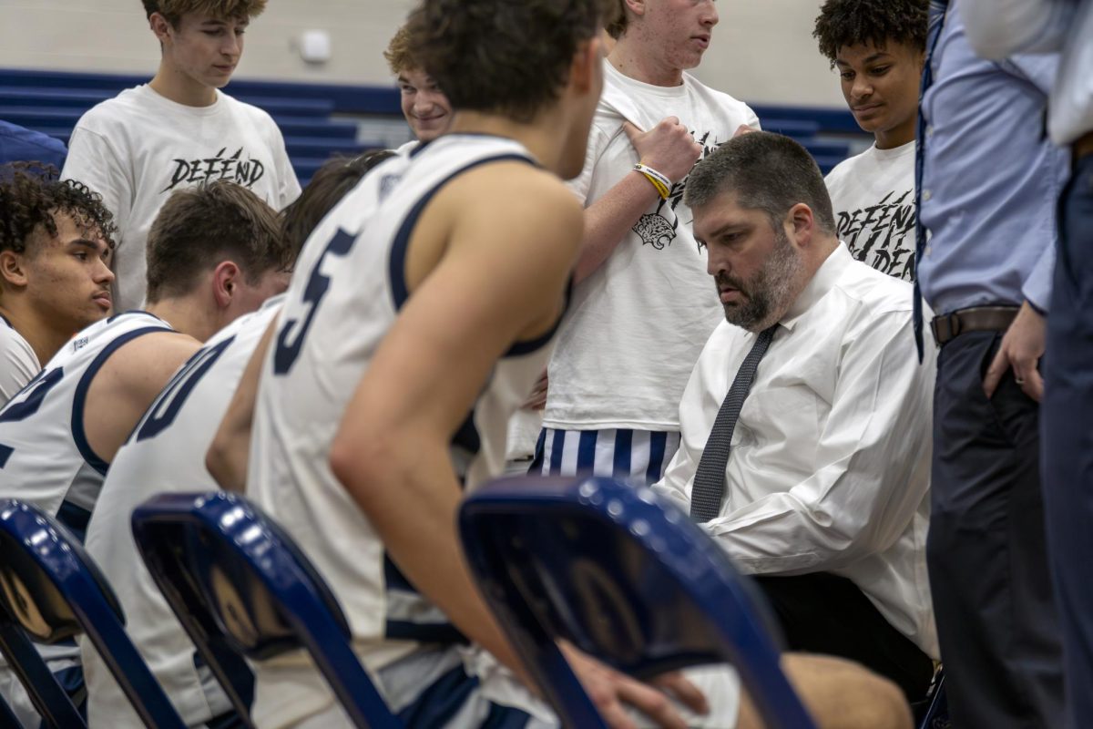Coach Kurt Bangle discusses the plan with the team for the last minute of the game. With the team down three, Bangle prepares for the loss.