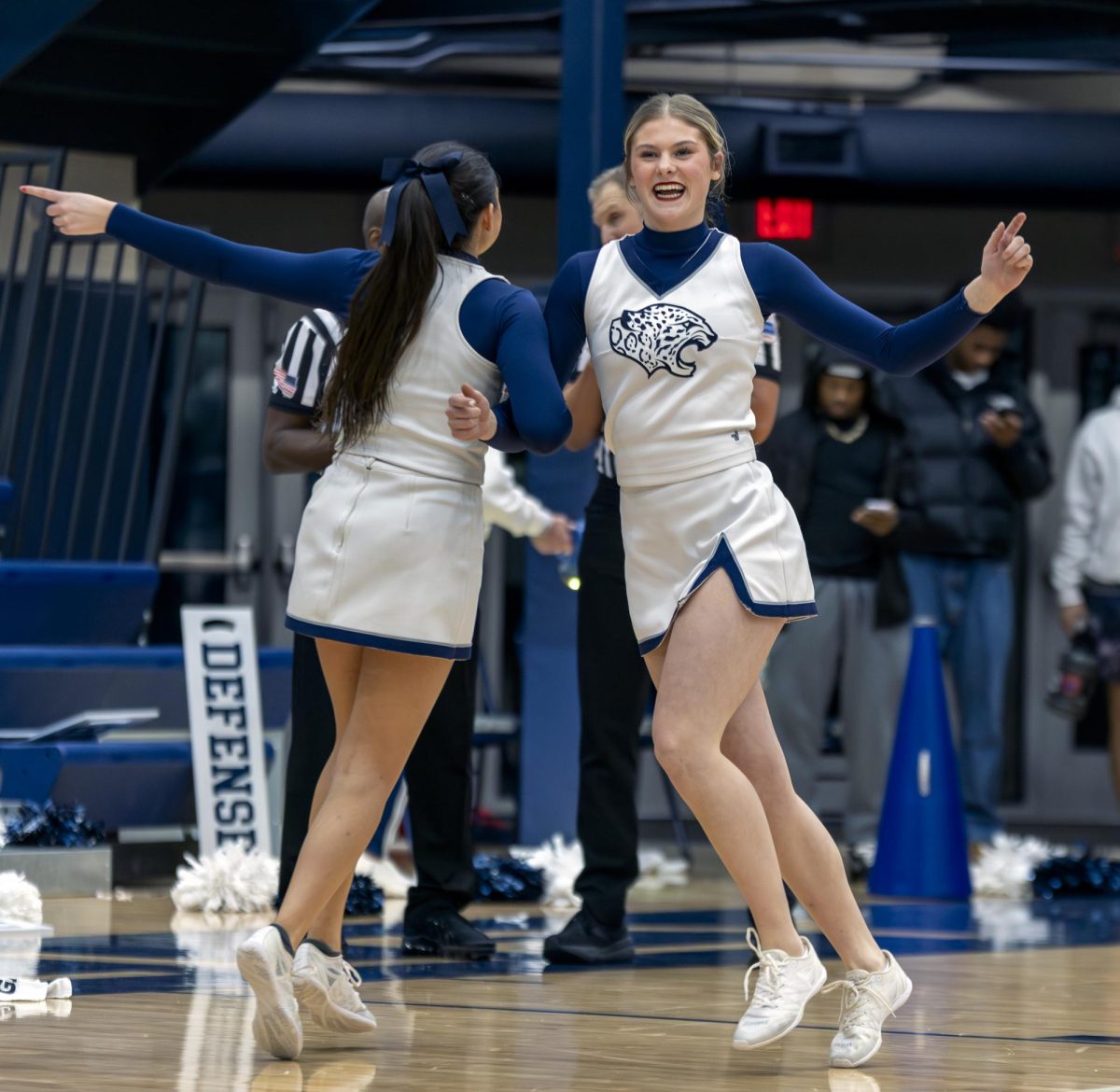Arms linked, senior Stella Biens and junior Kenna Long dance to “Cotton Eye Joe” during a timeout