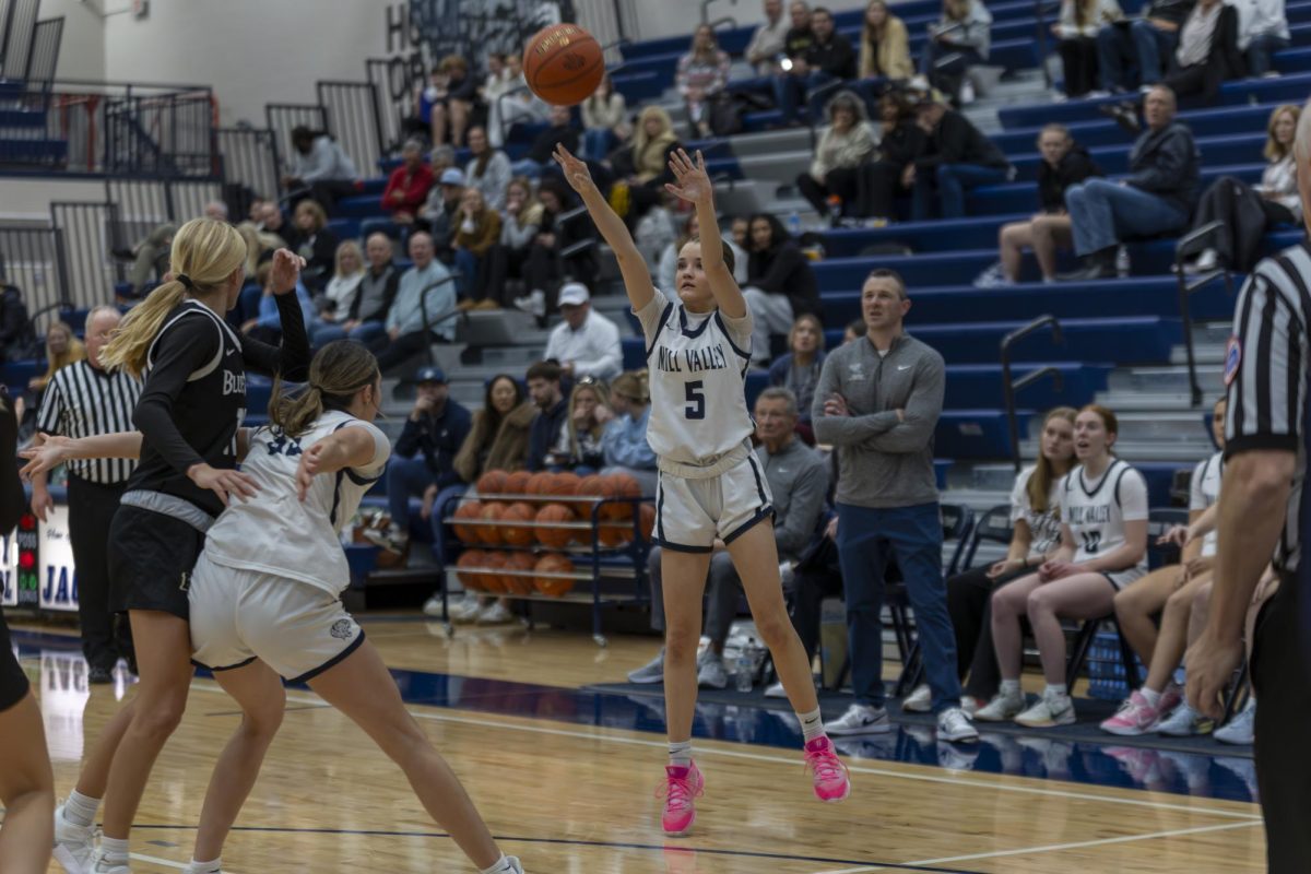 Sophomore Elin Diskin shoots for three while junior Faith Pittenger protects her