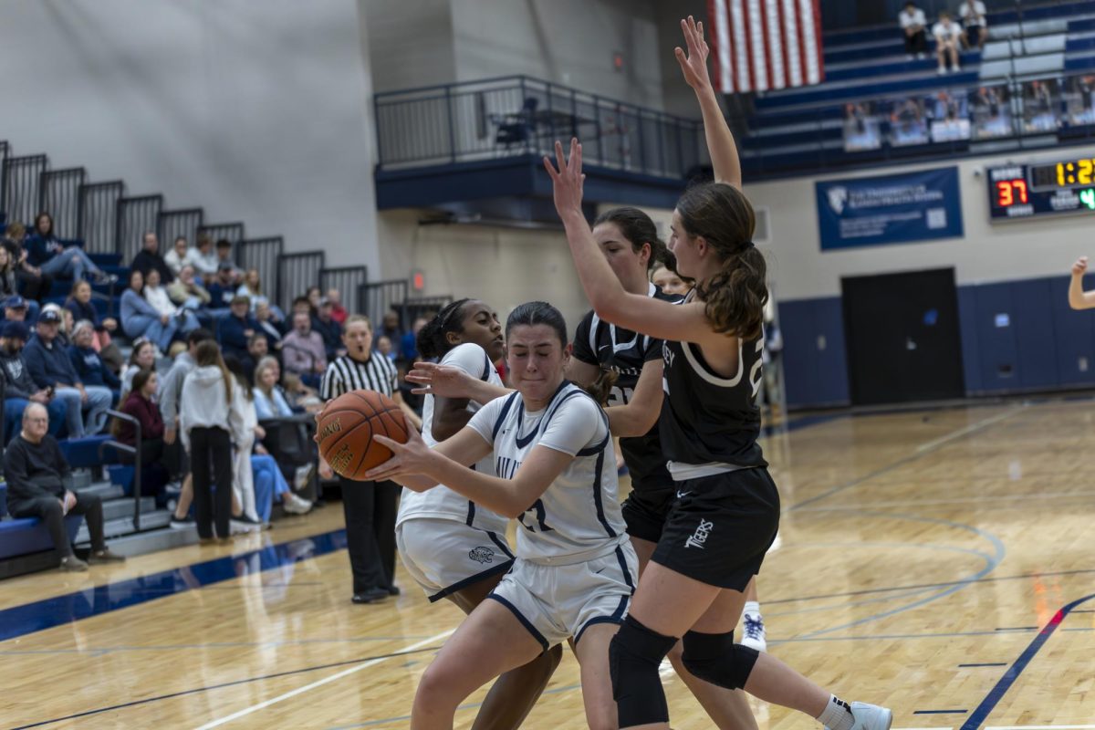 Senior Paige Roth prepares to make a pass after being hit by a defender