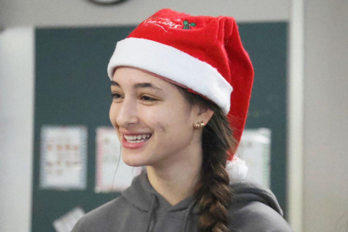 Sophomore Elynne Strack smiles after she finishes singing to a carol gram recipient 