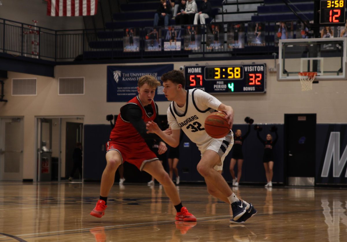 Eyes on his teammates, senior Carter Clark dribbles down the court.
