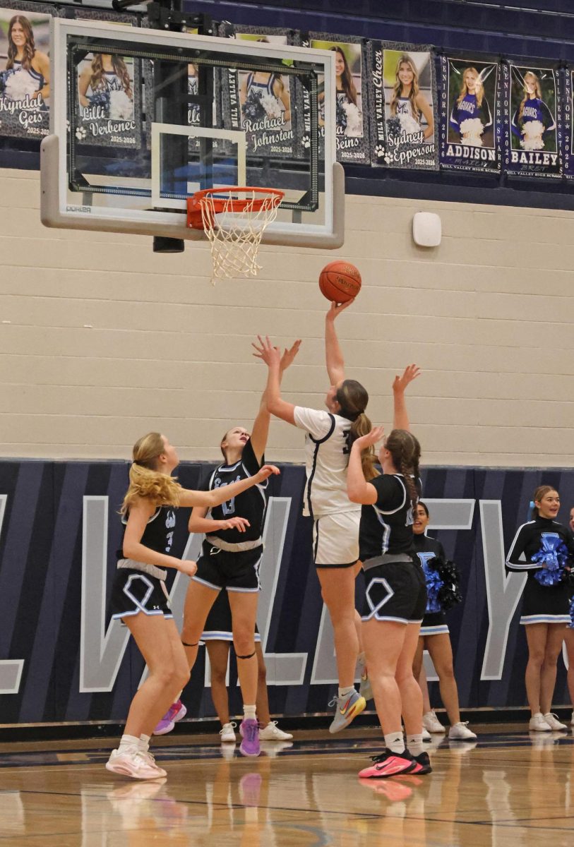 Going up for a contested layup, sophomore Emily Izatt scores a basket.