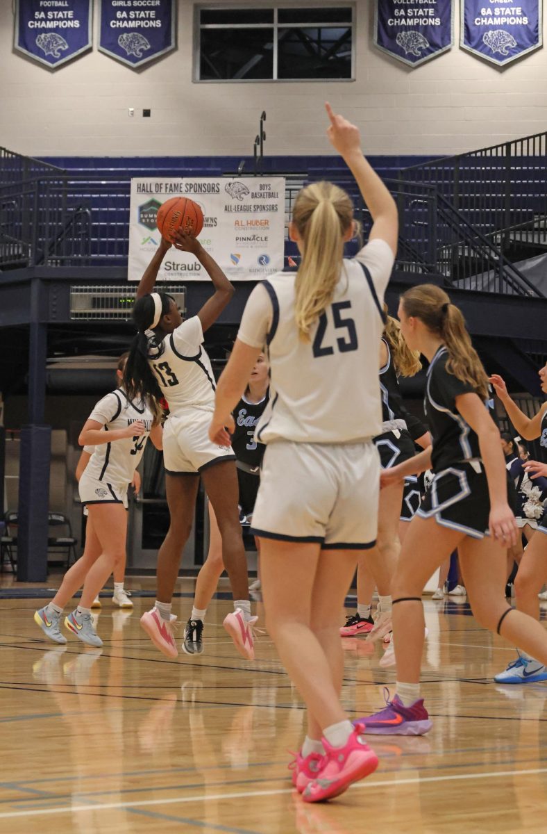 Calling the shot, junior Riley Marshall watches as freshman Tavia Barton throws up a shot.