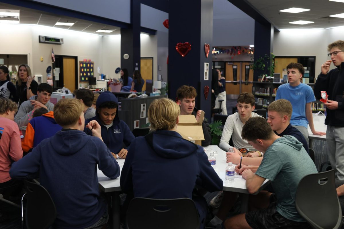 Brainstorming thoughtfully, the basketball team writes down what they believe is the best answer. 