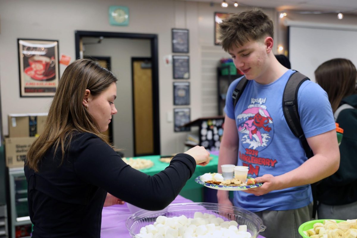 Senior Maddie Martin gives sophomore Jack Musil a marshmallow.