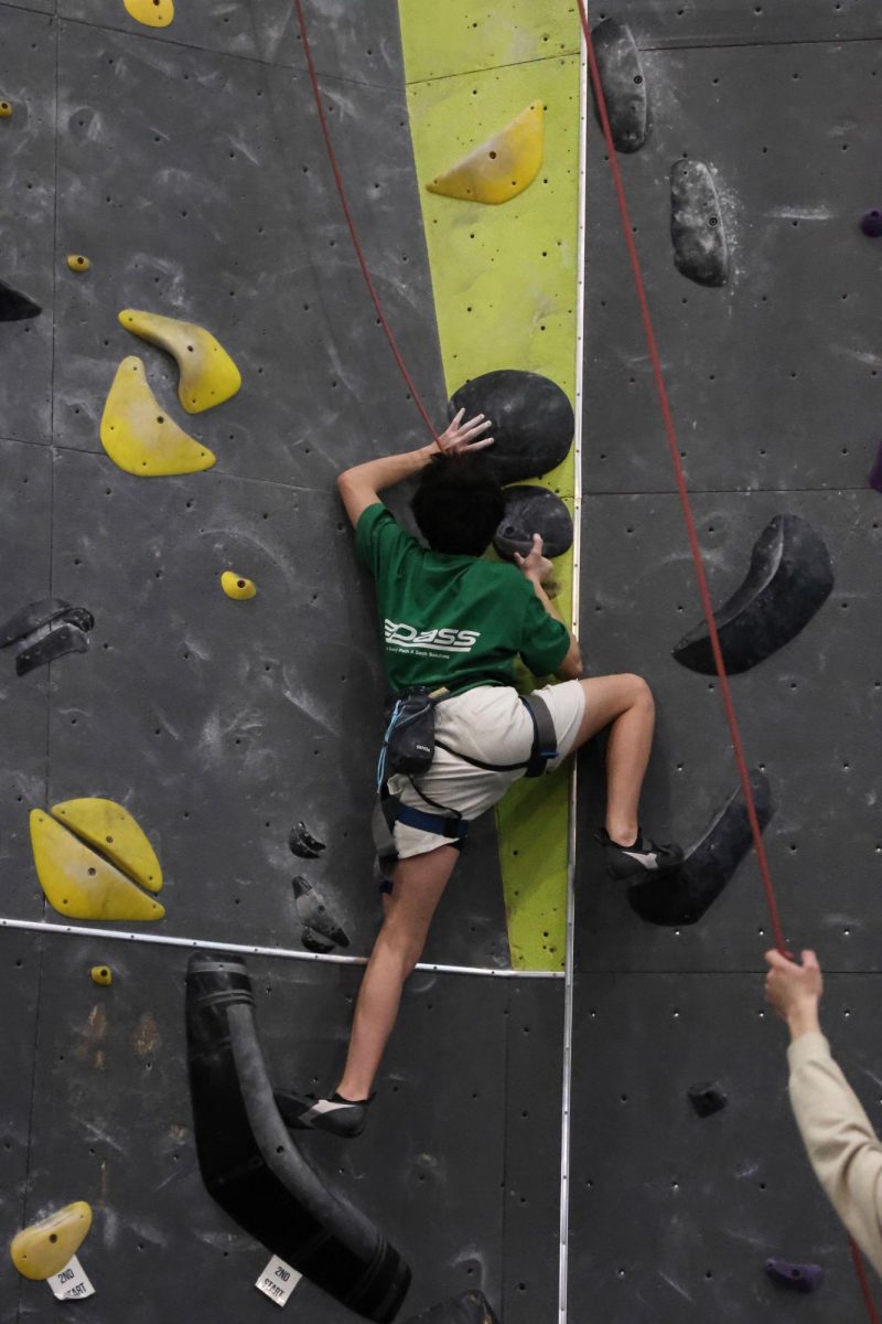 Sophomore Issac Grimm begins his journey up the 50 foot wall, mapping out how he's going to do it.
