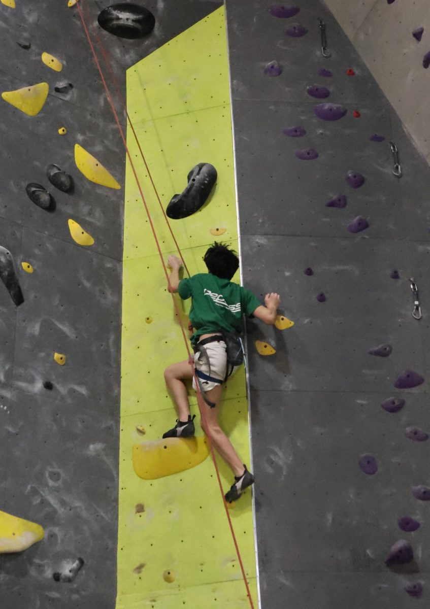 Sophomore Issac Grimm approaches the top of the 50 foot wall.
