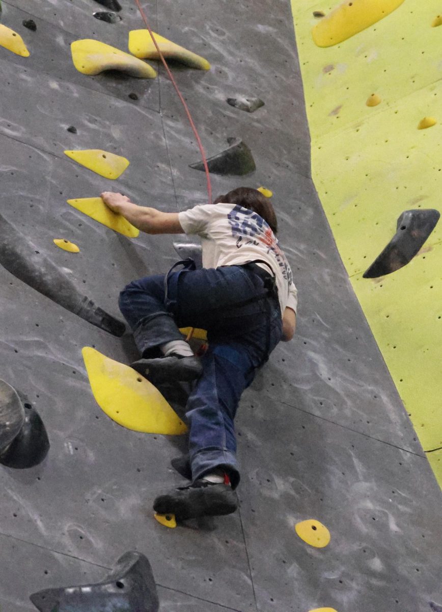 Sophomore Calder Hsu reaches halfway up the 50 foot wall.
