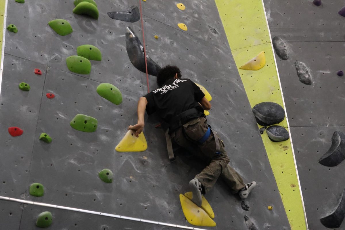 Junior Sebastian Puello reaches his foot in hopes to use rock to boost himself up.
