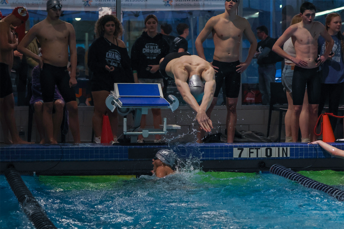 Sophomore Cole Hansen dives into the water over Junior Turner bruce during the 200 meter relay