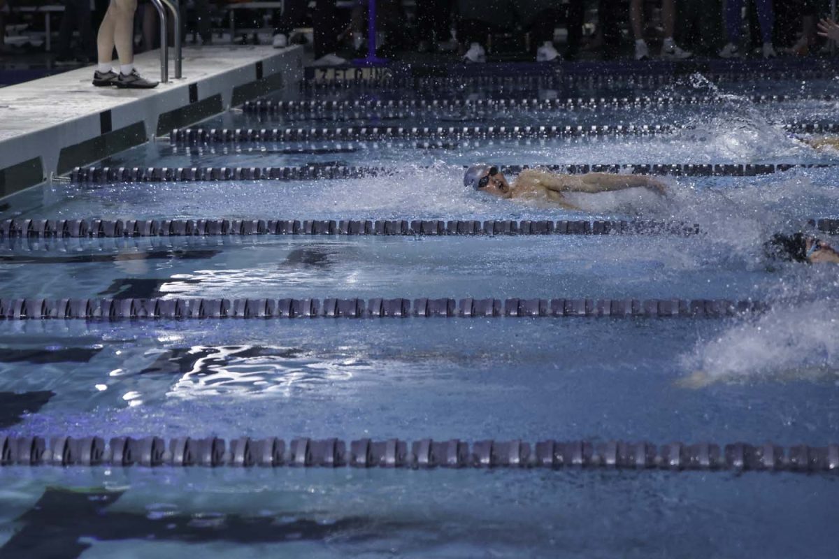 Junior Andrew Martin swims down the lane ahead of his competitors