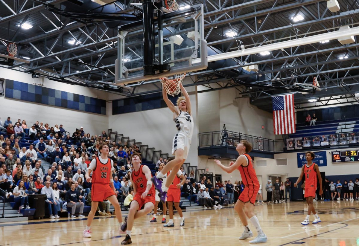 Senior Dylan Everhart dunks in the last two minutes of the game to help the team stay ahead