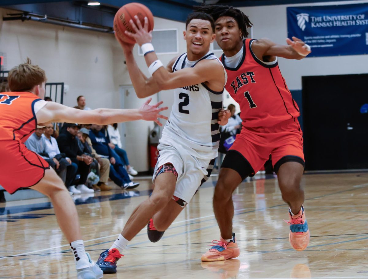 Senior JaKhai Carter runs through two defenders to pass the ball to his teammate