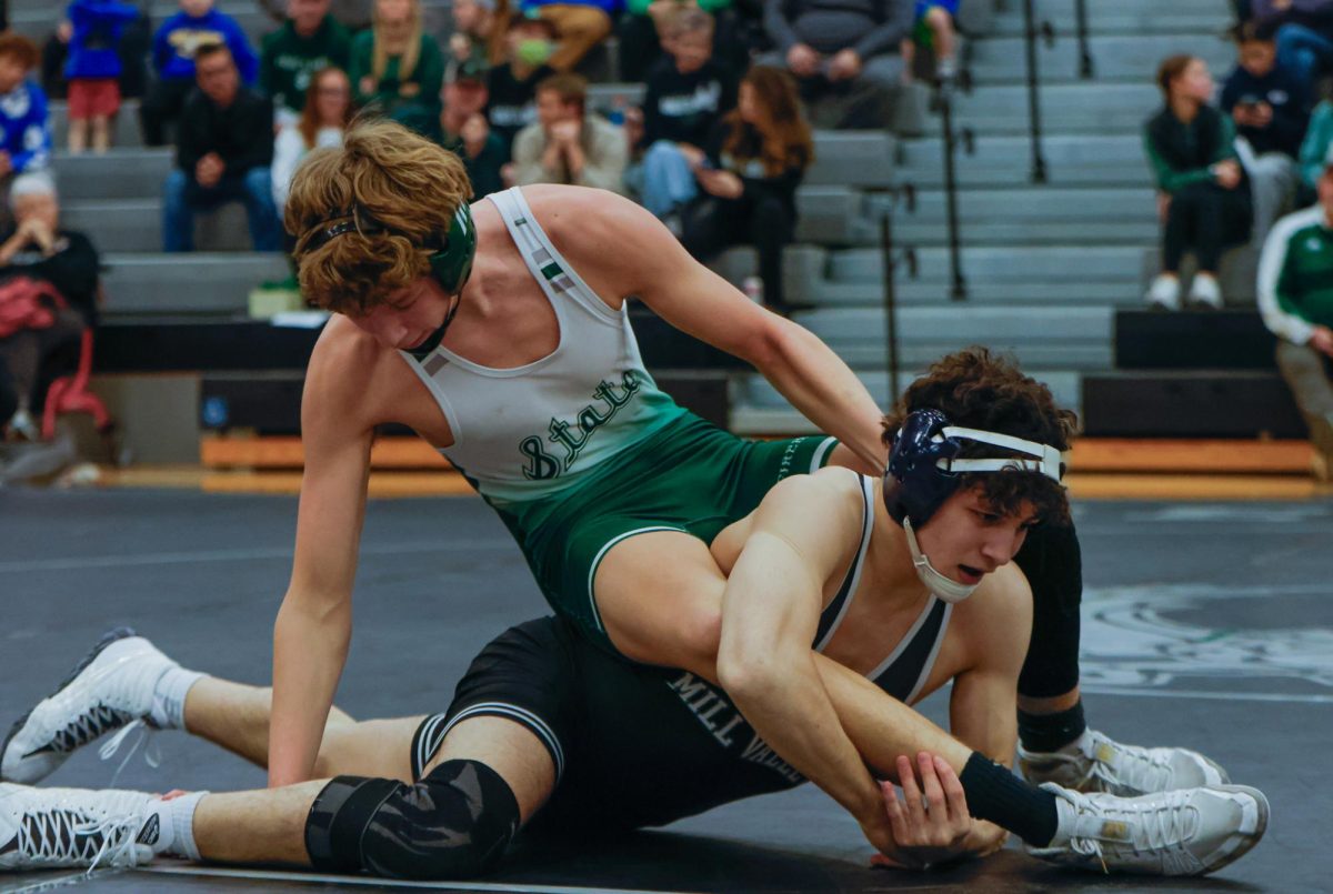 Grabbing his opponent's leg, junior Luke Whisler attempts to drag him down. 