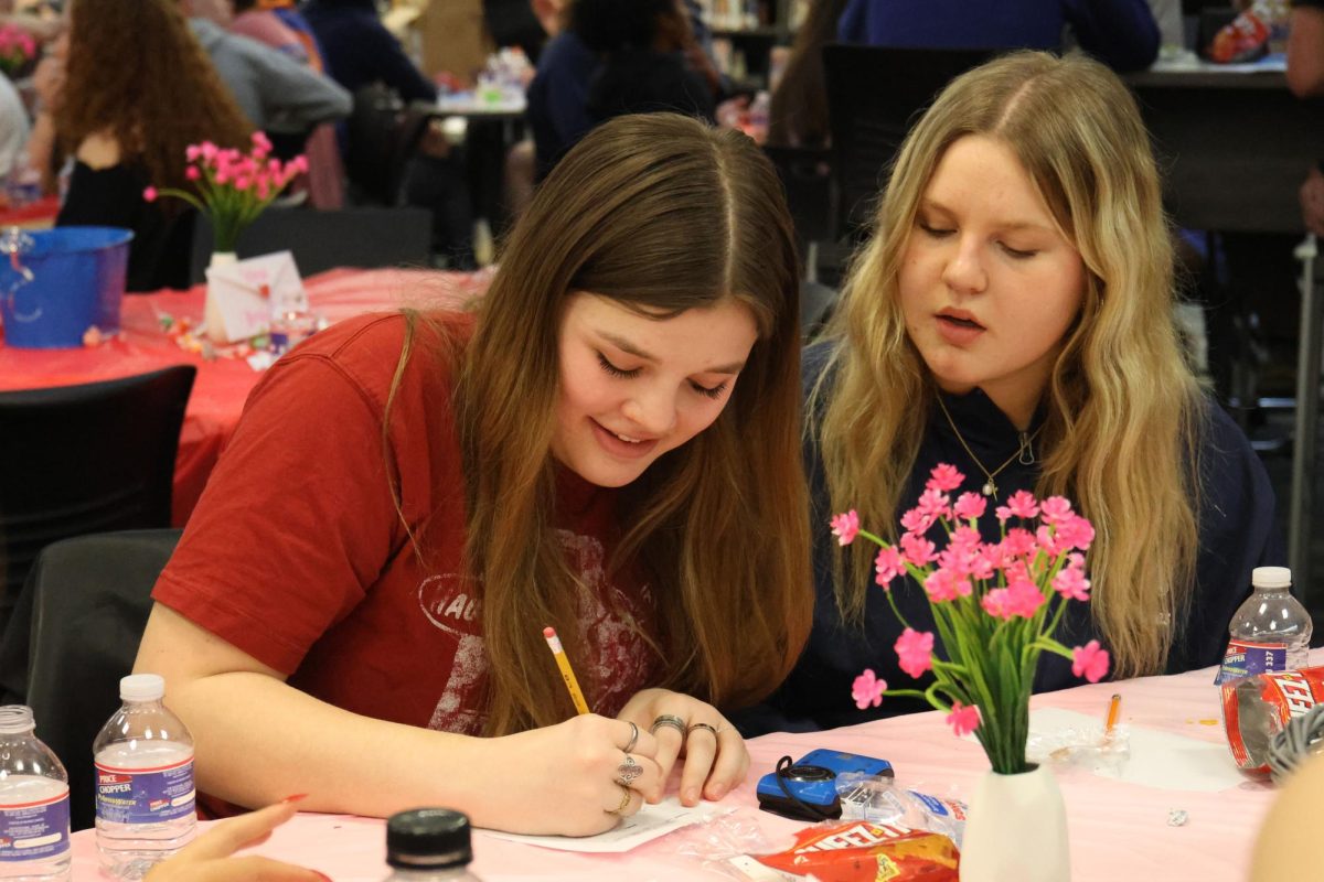Seniors Ava Mendez and Emma Lee write down answers for their team during WOCO trivia night, Friday, Feb. 13. 