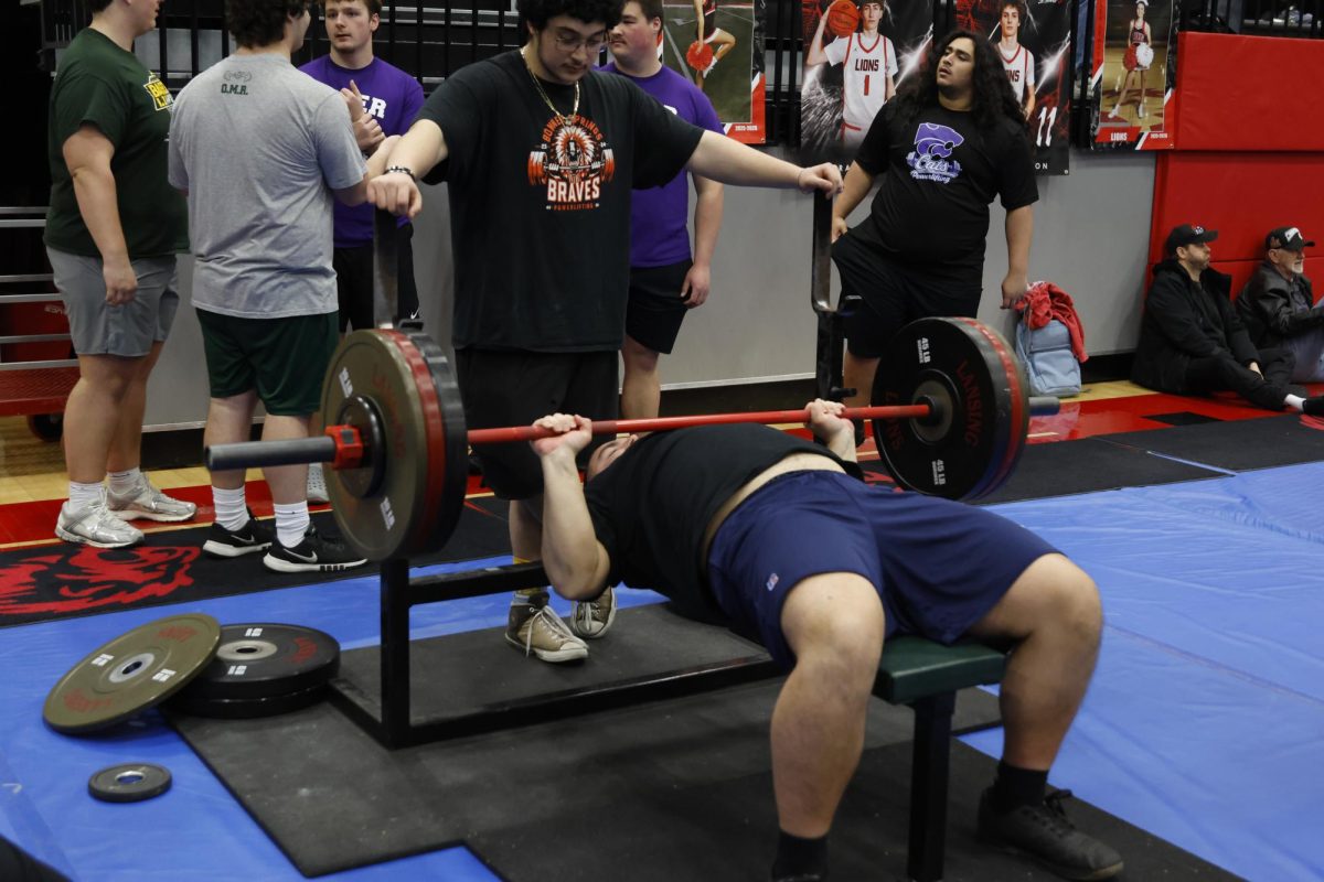 Senior Hayden Heller warms up on bench with 205lbs at the Lansing powerlifting meet on Feb. 7.