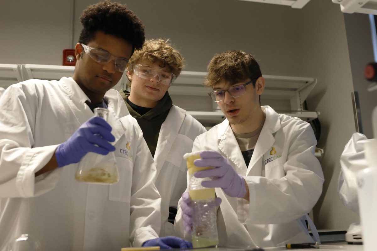 Filtering out any debris, junior Nate Tolla and seniors Riggs Lamborn and Alex Kempker work to create their own filter to make clean water in the bioscience lab at CTEC, Friday, Jan. 23.