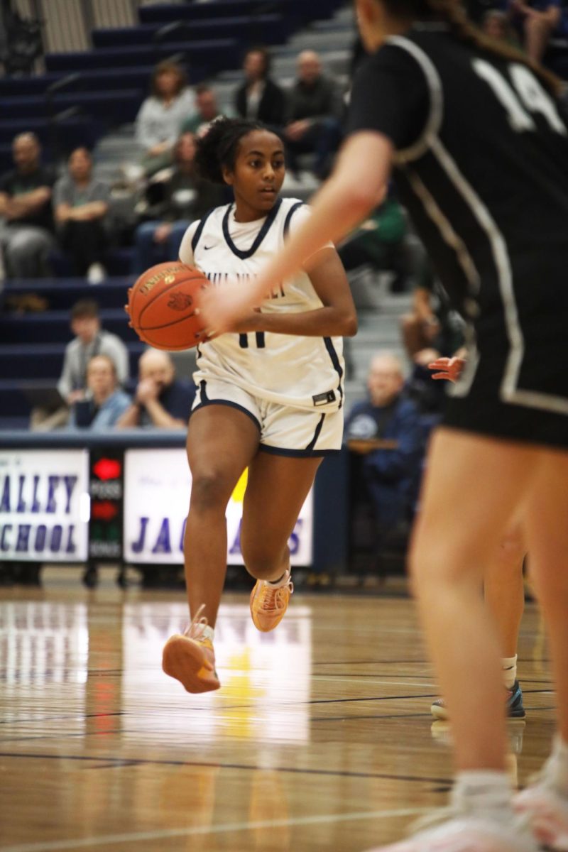 Dribbling down the court, junior Biti Hasabu looks for an opening to score. 