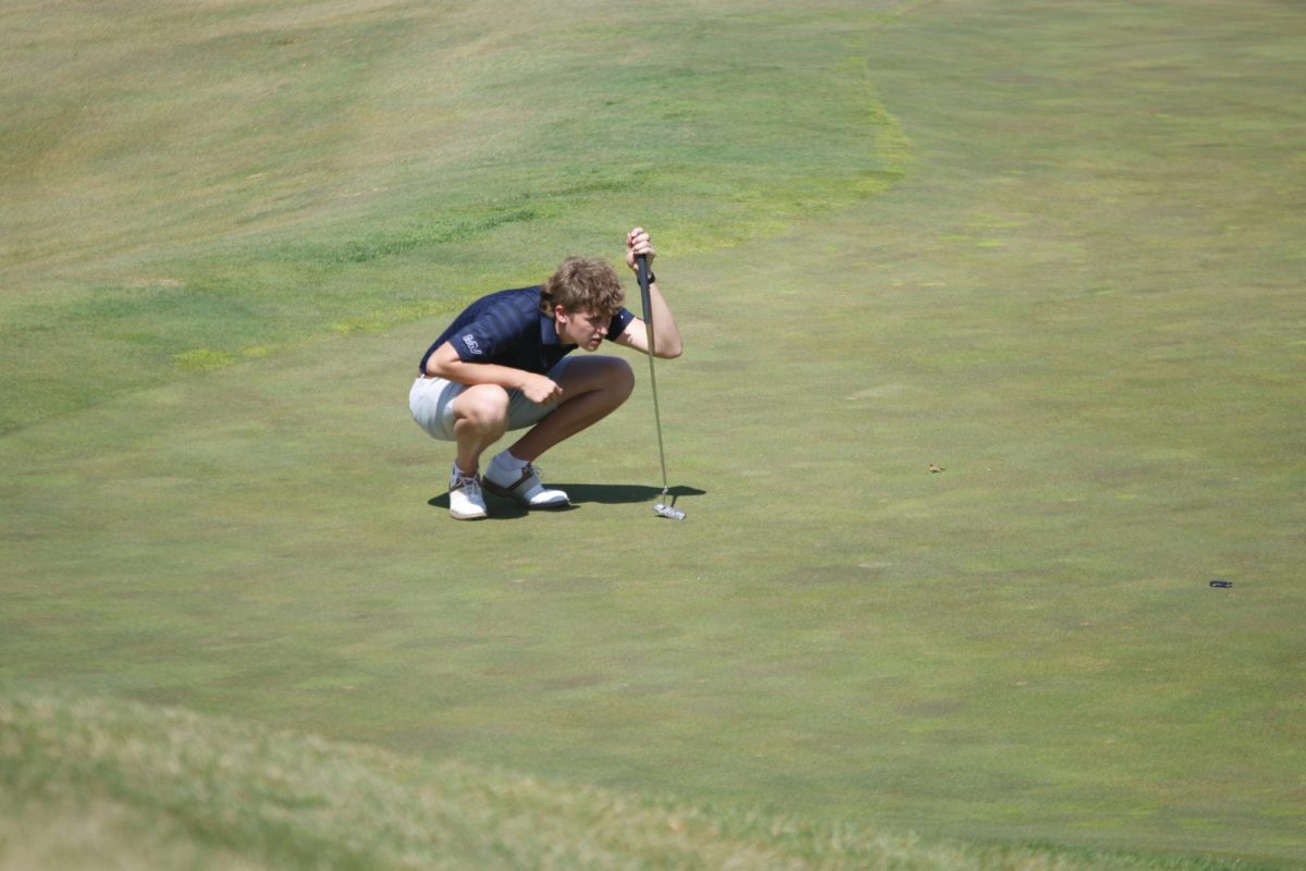 Senior Cannon Fields studies the course to decide his next shot.