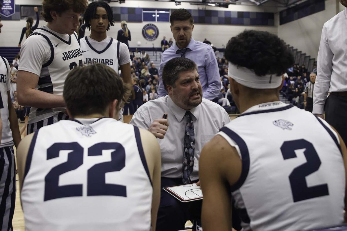 Early in the game, the team huddles up around coach Kurt Bangle to discuss how to keep their lead