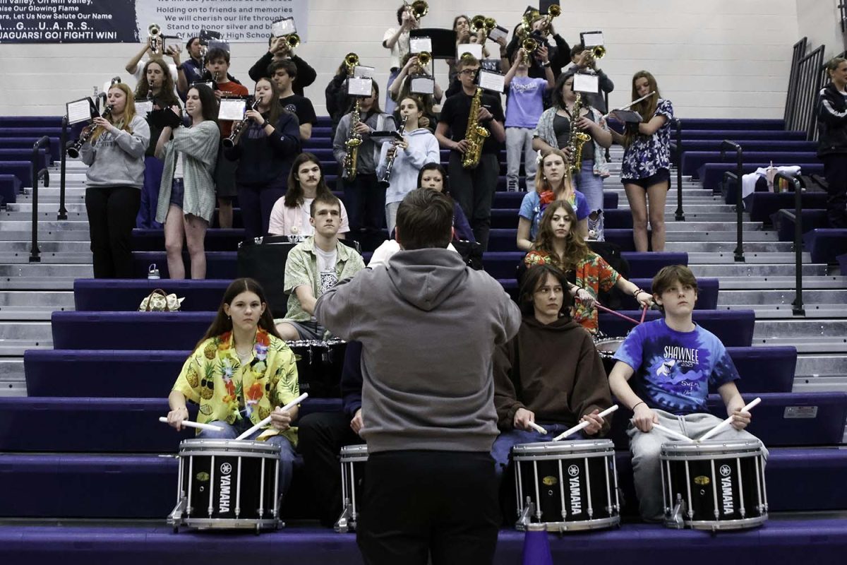 Senior Ian Weatherman leads the band in the national anthem to kick off the game