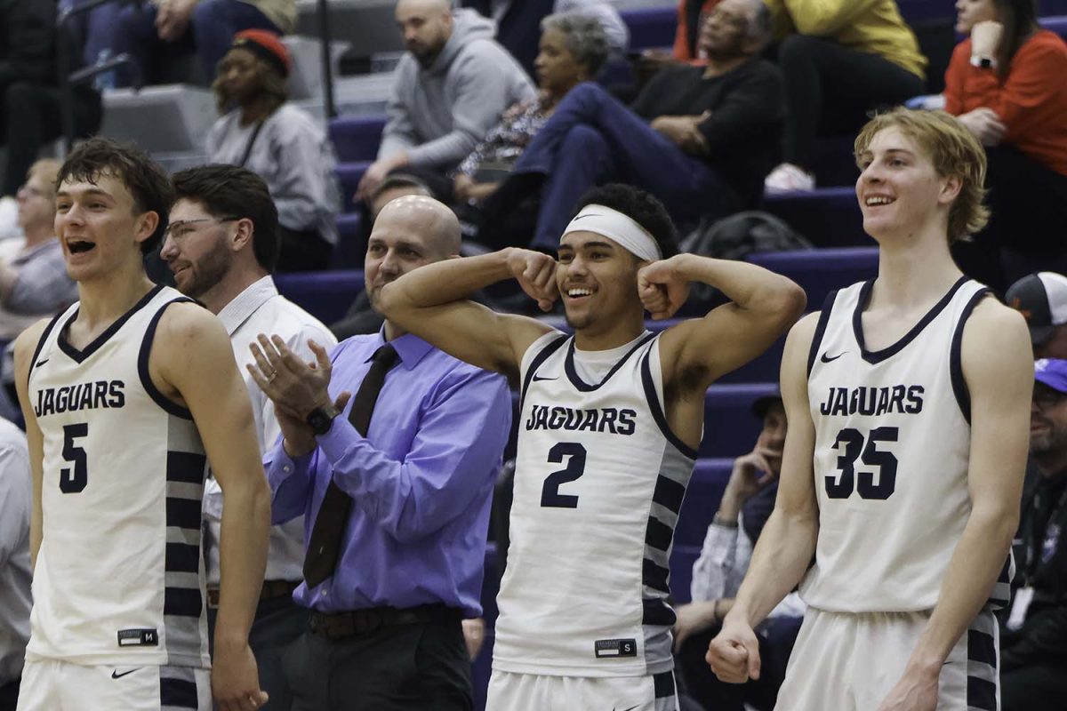 Seniors Reece Reidel, JaKhai Carter and Dylan Everhart celebrate on the bench after an underclassman scores