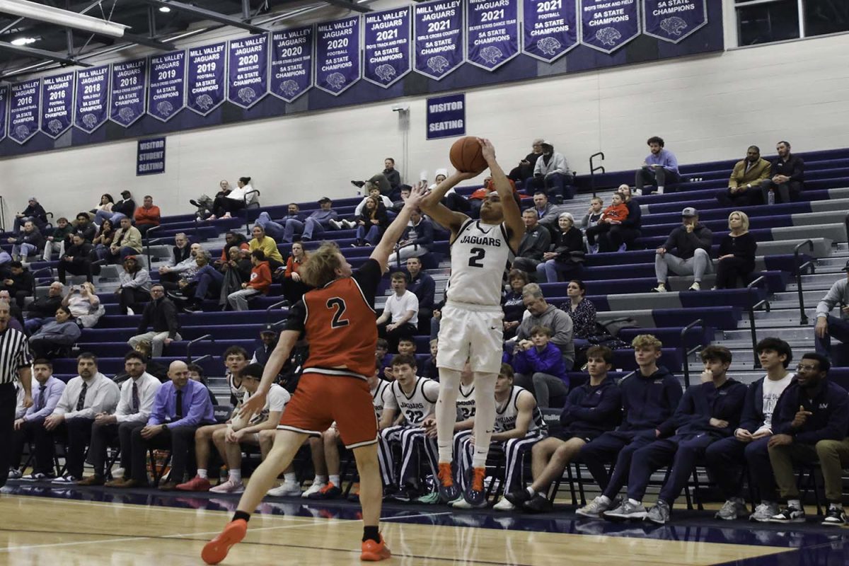 Senior JaKhai Carter jumps to shoot a three pointer