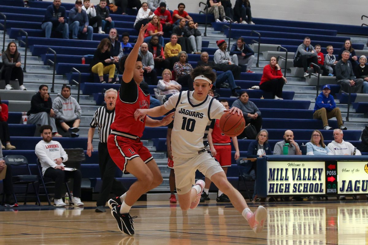 Battling his defender, senior Jack Carpenter dribbles into the center lane, Wednesday, March, 4