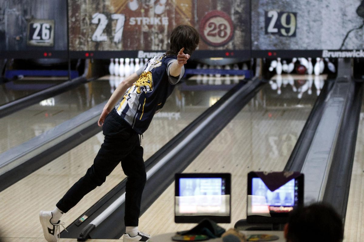 Celebrating his third strike in a row, senior Jake Brown points to his team