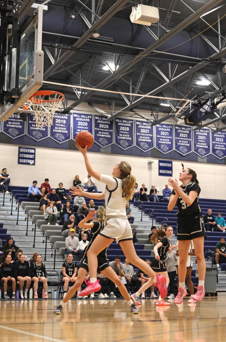 Making her layup, junior Riley Marshall maneuvers past the defenders.
