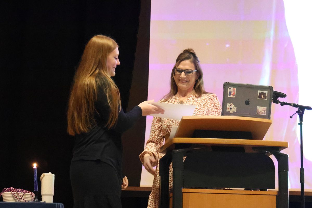 Madame Smith honors junior Alexa Lamoureux with certificate of membership in the French NHS during the induction ceremony, Friday, Feb. 24.
