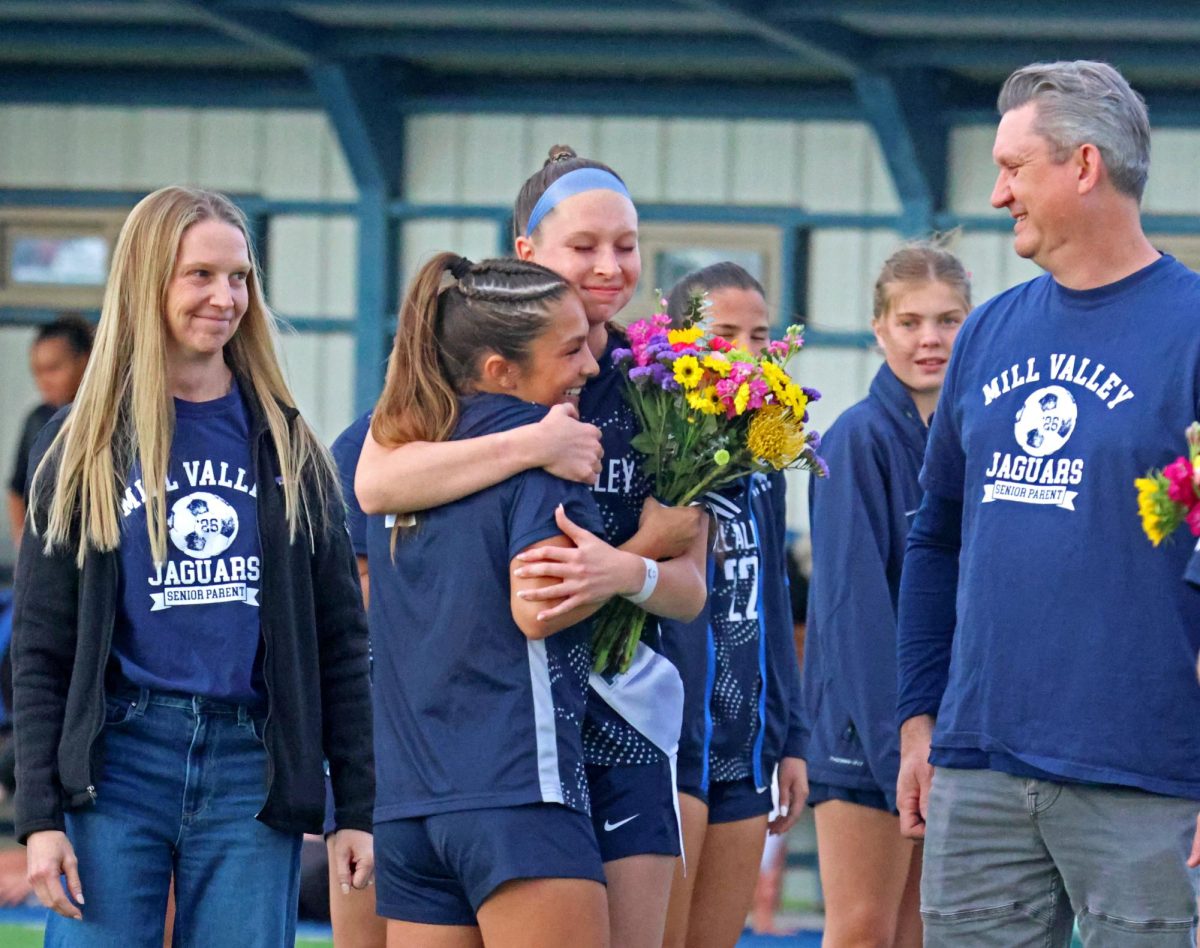 Junior Paige Frost hugs senior Sydney Nash while celebrating her during senior night. .
