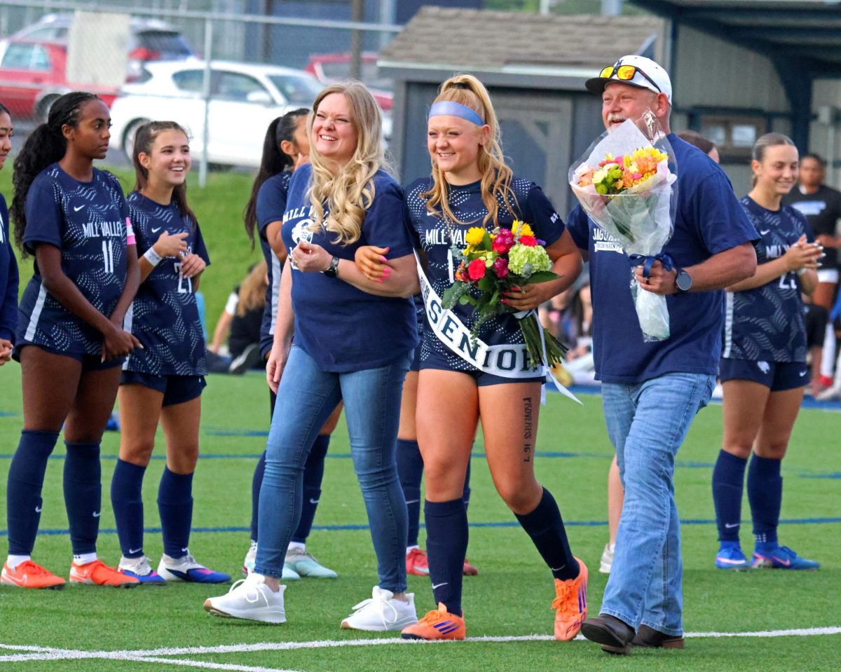 Approaching coach Justin Crawford, senior Emma Carbajo walks with her parents.
