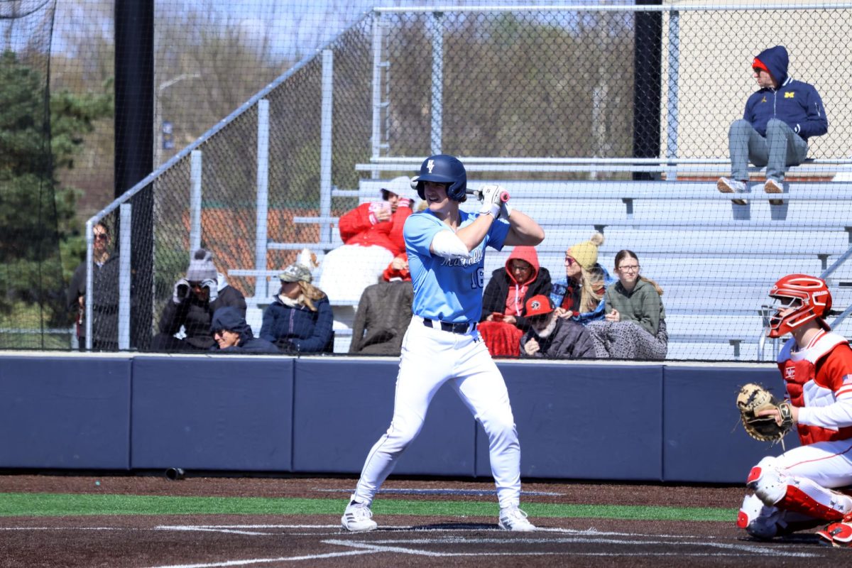 Getting into his stance, senior Beau Peterson hits a single as the first hit of the game. 