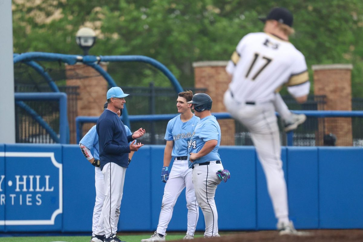 During a break, coach Jeff Strickland discusses the plans with seniors Beau Peterson, Micah Ammann and junior Easton Engelhart who are all on base