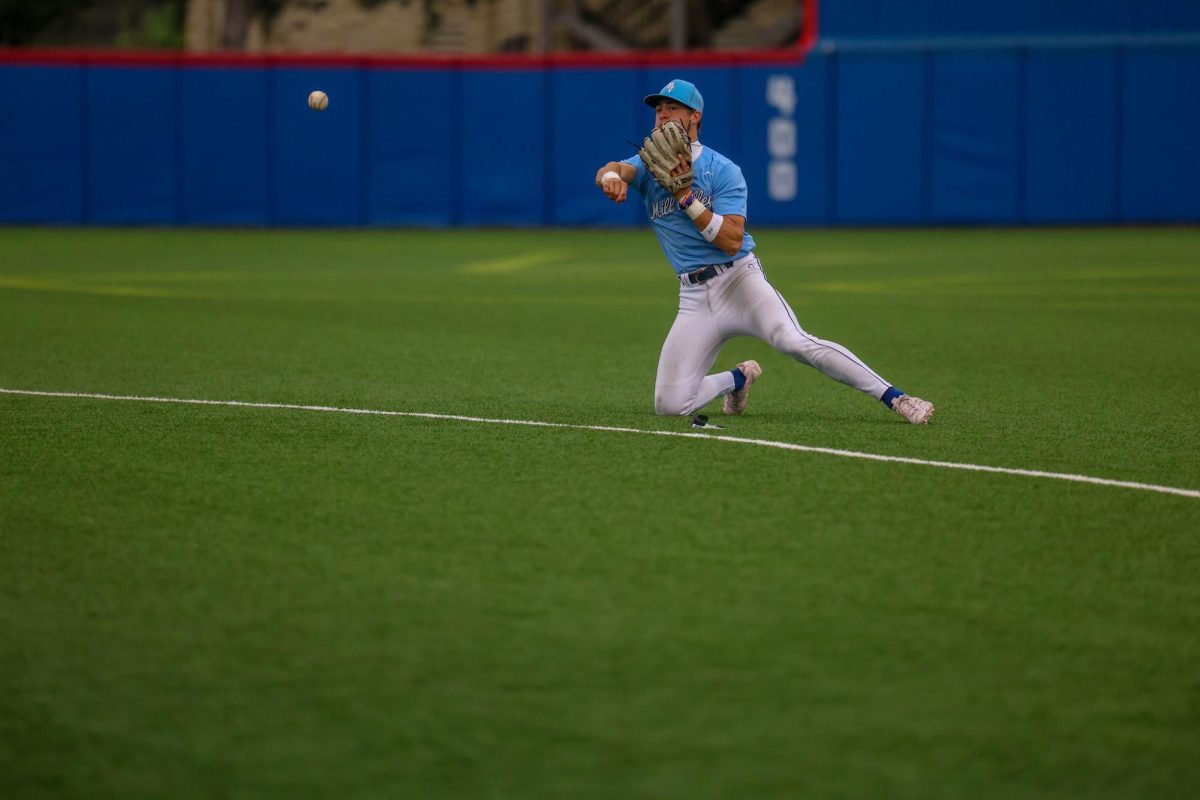 After diving for a catch, senior Blake Jay passes the ball to first base 