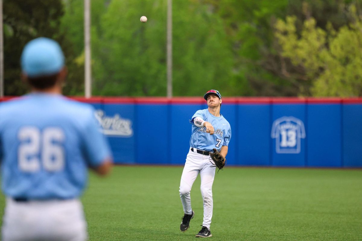 in between innings senior Micah Ammann plays catch to warm up