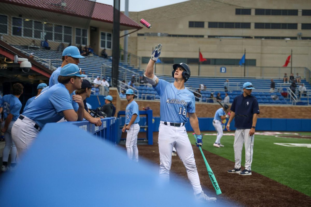 Getting ready to bat, senior Beau Peterson catches a can of pine tar to put on his bat